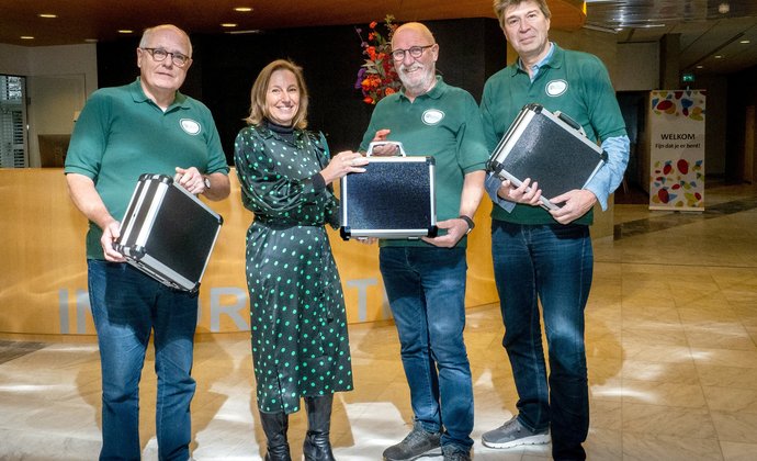 Wethouder reikt de koffers met meetapparatuur uit aan de energiecoaches